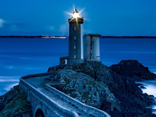 Magia Costiera Notturna: Il Fascino Ipnotico di un Faro sotto le Stelle
