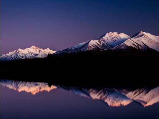 El abrazo de Twilight: un reflejo de las montañas nevadas